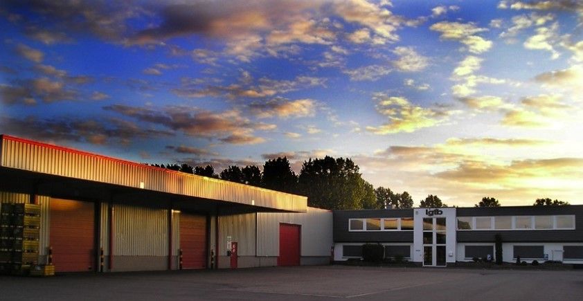 Magazijn met laadkades en kantoorgebouw bij zonsondergang